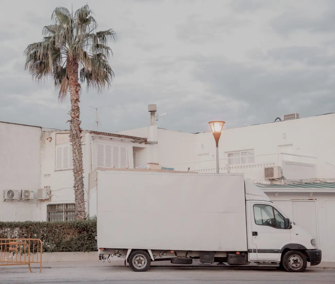 A box truck parked square to the kerb in side view, the whole box flank left blank