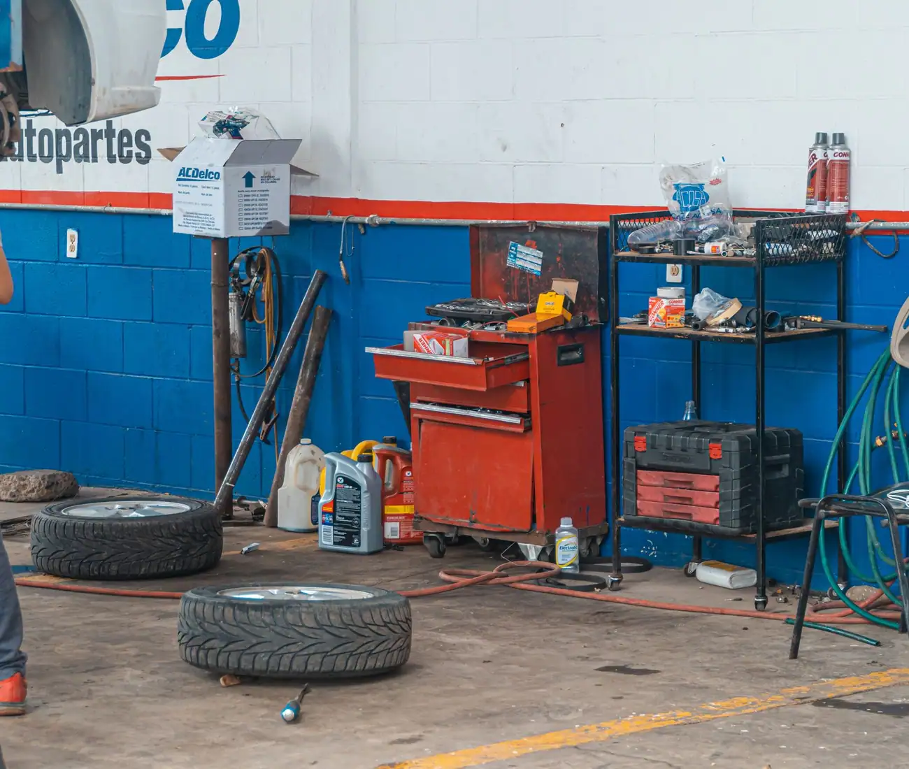 A working garage interior with tool boards, tyres and equipment