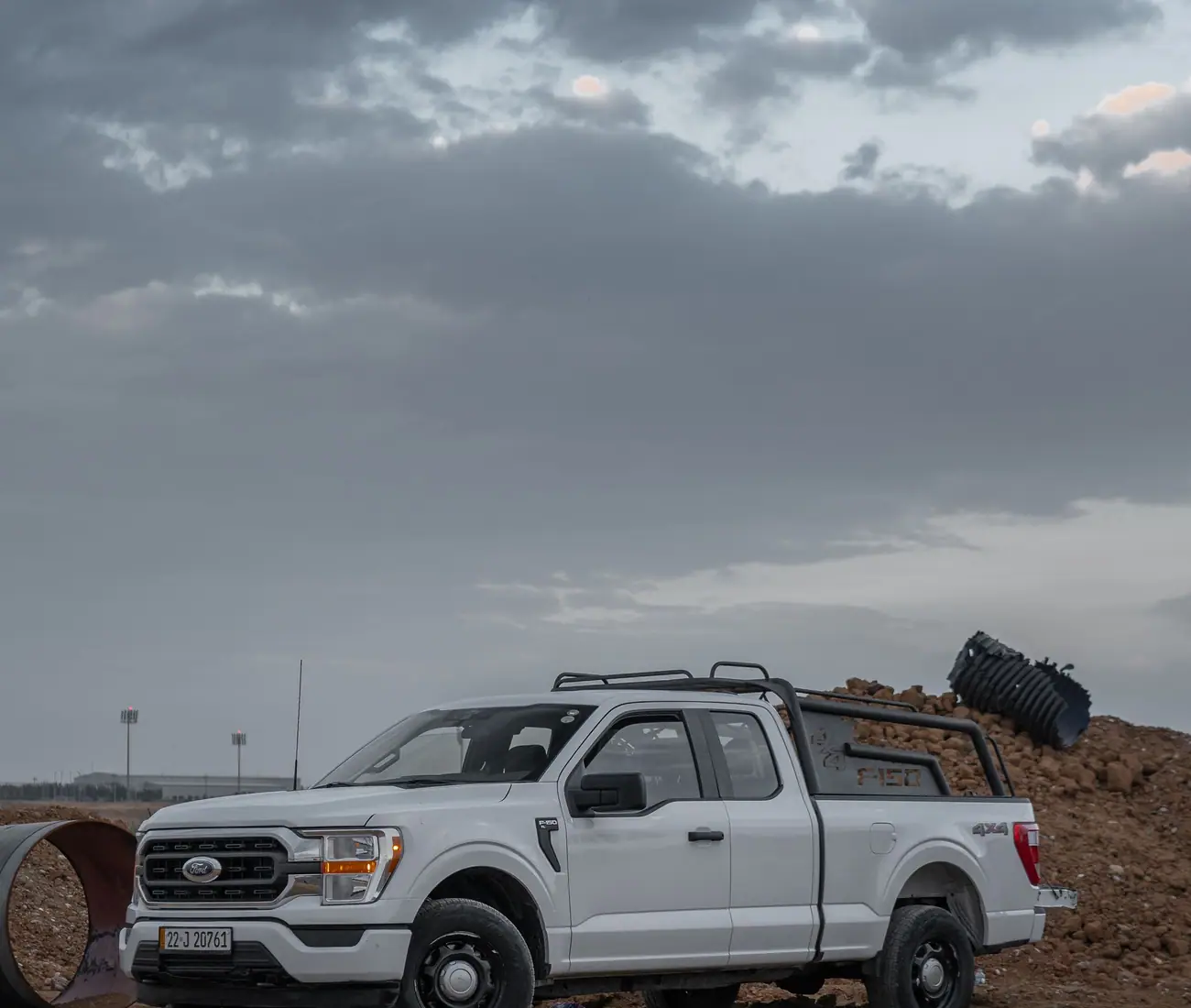 A white crew cab pickup parked at a dirt work site