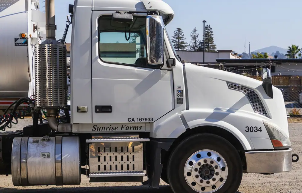 A tractor cab door carrying a carrier name, a state DOT number and a unit number, cut and set square