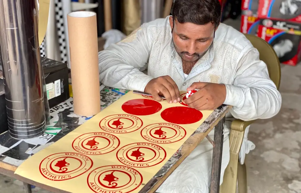 Cut vinyl pieces being weeded and separated on a bench before they go anywhere near a vehicle